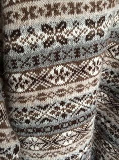 the back of a sweater with brown and white designs on it