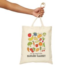 a person is holding a bag that says farmers market with fruits and vegetables on it