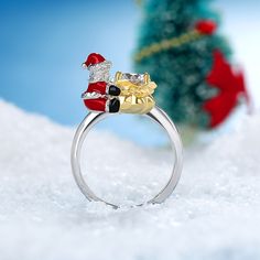 Enjoy the magic of Christmas with this ring. Inspired by Santa Claus, this ring in Hug Me® collection shows a baby with red Christmas hat, red Christmas clothes. Crafted in sterling silver, this one features this lovely Christmas baby that hugged the center stone. You will instantly fall in love with this cute design. You will find more adorable and creative designs in our Hug Me® collection.Carat Weight: 1.9 ctStone Size: 6.5 mmStone Type: Jeulia® StoneNumber of Stones: 1 Stone Color: Diamond WhiteStone Shape: RoundWeight: 5.25 gWidth: 2.8 mmHeight: 9.9 mmThickness: 1.6 mmMaterial: 925 SilverPlating Color: Silver, Yellow Gold Christmas Clothes, Christmas Rings, Baby Candy, Christmas Ring, Ring Inspired, The Magic Of Christmas, Magic Of Christmas, Christmas Hat, Candy Bags