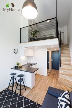 a kitchen and living room with stairs leading up to the second floor in this modern home