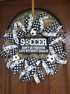 a soccer wreath with black and white polka dots is hanging on the front door,