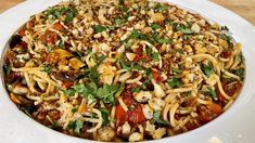 a white bowl filled with pasta and vegetables