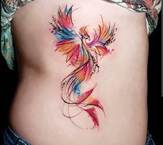 a colorful bird tattoo on the side of a woman's stomach