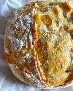 a baked pastry sitting on top of a piece of wax paper covered in powdered sugar