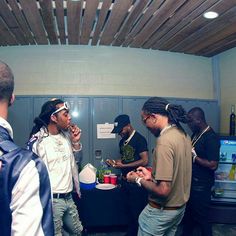 several young men standing around a table with food and drinks on it in front of lockers