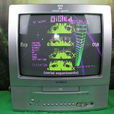 an old tv sitting on top of a green table next to a wallpapered background