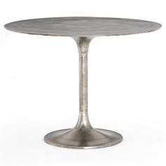 a round metal table sitting on top of a white floor