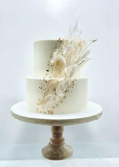 a three tiered cake with white frosting and gold decorations