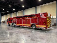 two red fire trucks parked in a warehouse