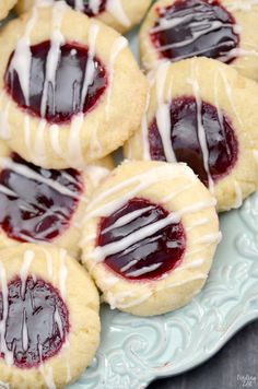 raspberry thumbprint cookies on a plate with white icing