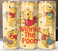 three winnie the pooh tumblers sitting on top of a table