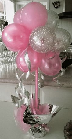 pink and white balloons in a vase on a counter