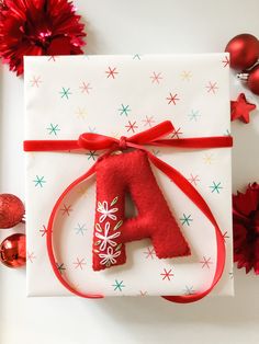 a present wrapped in white paper with a red number 4 on it next to christmas decorations