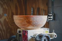 a wooden bowl sitting on top of a machine