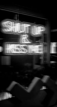 black and white photograph of a sign that says shut up & kiss me