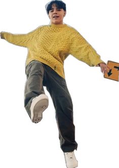 a young man is jumping in the air with his skateboard and wearing a yellow sweater