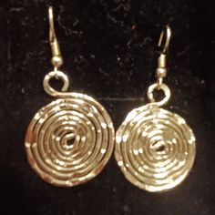 gold earrings with spiral design on black background