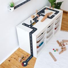 a child's play area with toys and wooden blocks on the floor, including a toy race track