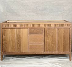 the sideboard is made from wood and has four drawers on one side, two doors on the other