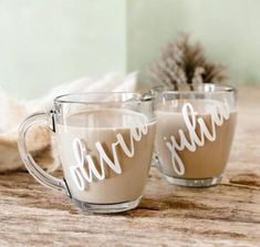 two coffee mugs sitting on top of a wooden table