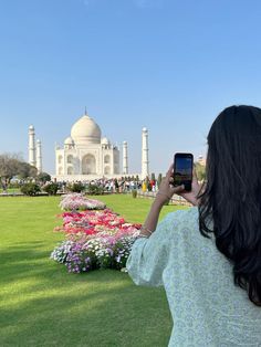 a woman taking a photo of the tajwa in india with her cell phone