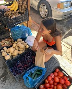 a woman sitting at a table with fruits and vegetables