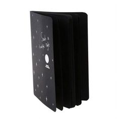 three black notebooks with writing on the front and back covers, one is open