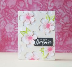 a white card with pink flowers on it