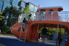 children are playing on an orange playground slide