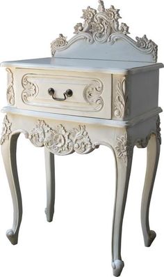 an ornate white table with drawers on the bottom and one drawer open to reveal something