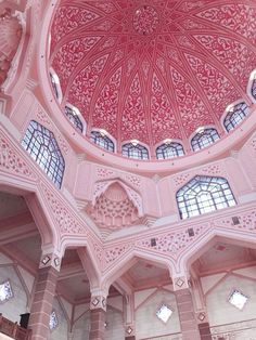 the inside of a pink building with many windows and arches on it's ceiling