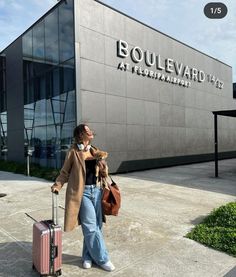 a woman is walking with her luggage and talking on the phone