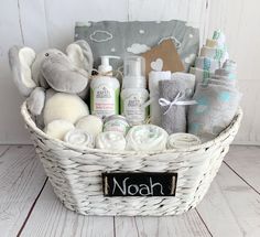 a white basket filled with baby items on top of a wooden floor