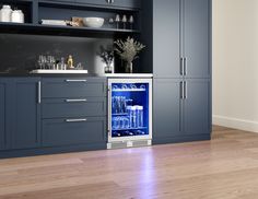 an open refrigerator in a kitchen with blue cabinets