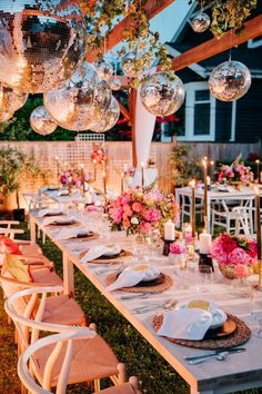 a long table set up with plates and silverware for an outdoor dinner or party