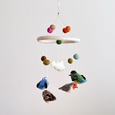 three birds are hanging from a mobile made out of felt