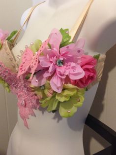 a white mannequin with pink and green flowers on it's headpiece