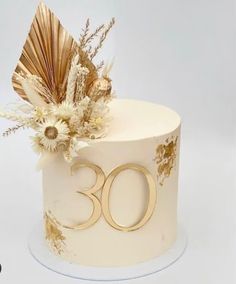 a white cake with gold decorations on top and the number 30 written in large letters