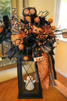 a vase filled with black and orange flowers on top of a wooden table next to a mirror