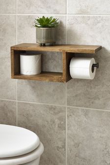 a wooden shelf with two rolls of toilet paper and a potted plant on top