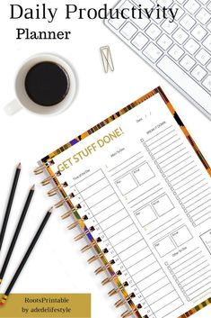 the daily planner is next to a keyboard and coffee cup on a desk with pencils