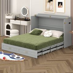 a bed sitting on top of a wooden floor next to a table with a mirror