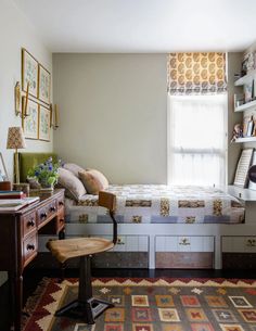 a bedroom with a bed, desk and chair next to a window in the corner