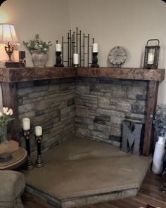 a living room with a stone fireplace and candles on the mantel above it is a clock