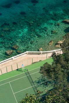 an aerial view of a tennis court near the ocean