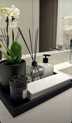 a bathroom sink with flowers and candles on it