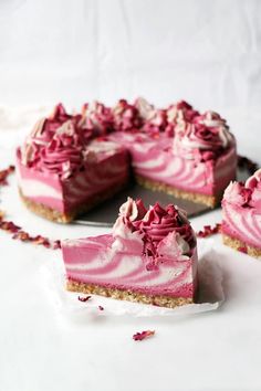 there is a piece of cake with pink frosting on the top and one slice missing