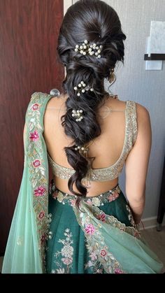 the back of a woman's head wearing a green lehenga