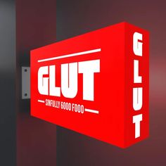 a red box with the word glut on it hanging from a metal wall