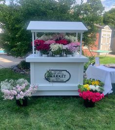 a market stand with flowers on display in the grass